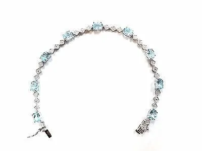 9 CARAT OVAL BLUE TOPAZ AND DIAMOND BRACELET IN RHODIUM PLATED BRASS